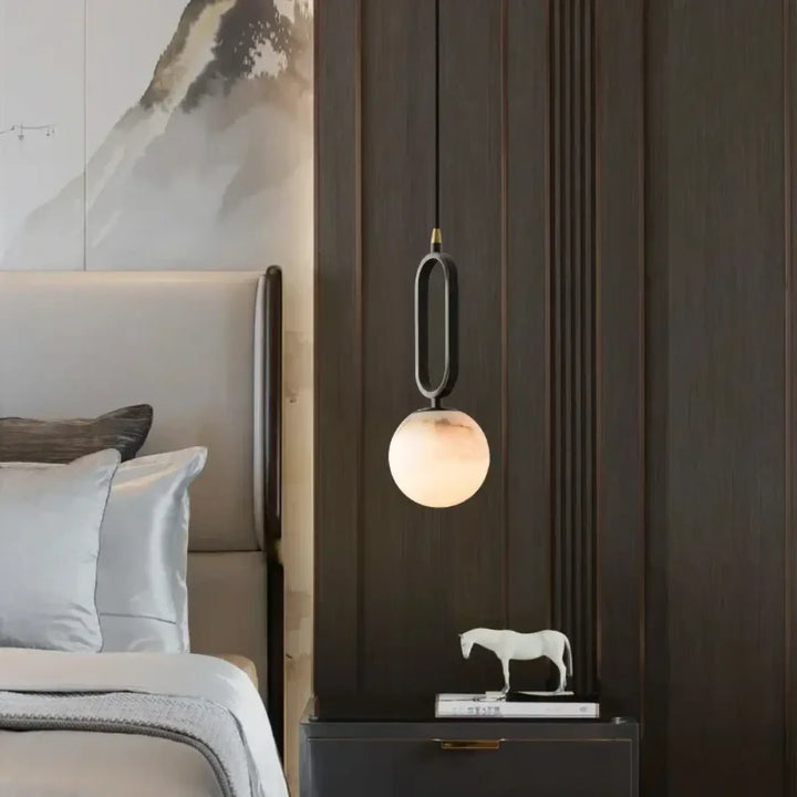 Suspension luminaire moderne marbria avec structure métallique noire et globe en verre diffusant une lumière chaude et douce