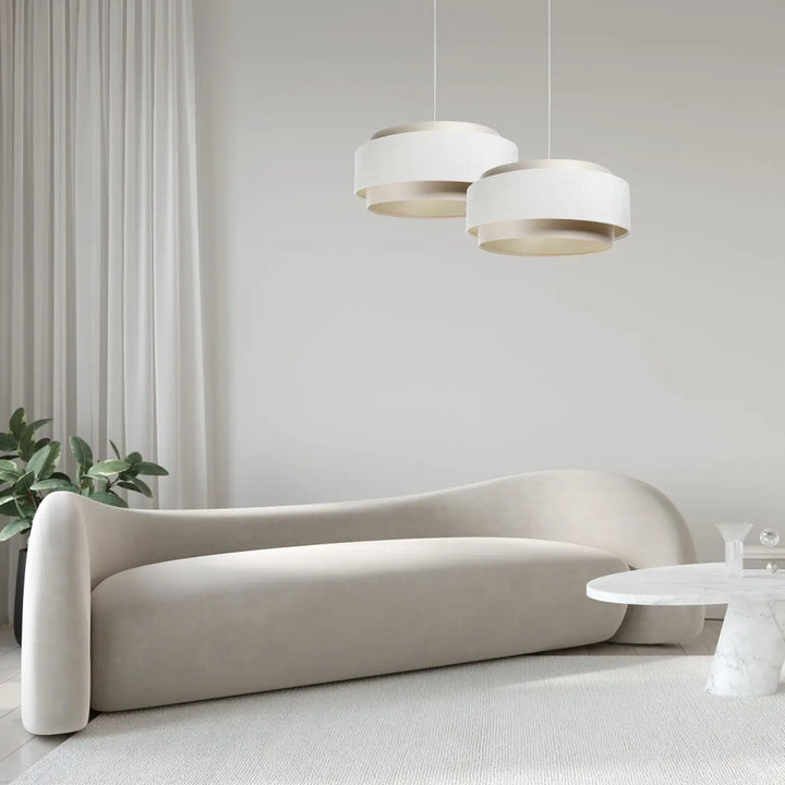 Canapé crème aux courbes élégantes en tissu crème s’accordant à une suspension luminaire moderne doblo classic