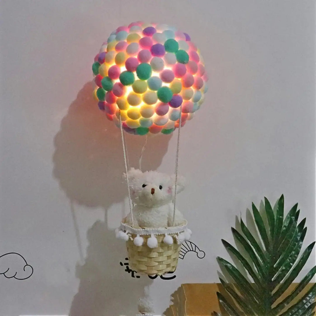 Veilleuse balou luminaire montgolfière pastel en pompons multicolores avec panier tissé et ourson blanc pour décoration intérieure