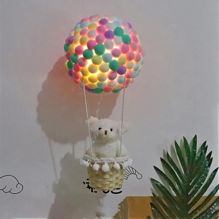 Veilleuse balou luminaire montgolfière pastel en pompons multicolores avec panier tissé et ourson blanc pour décoration intérieure