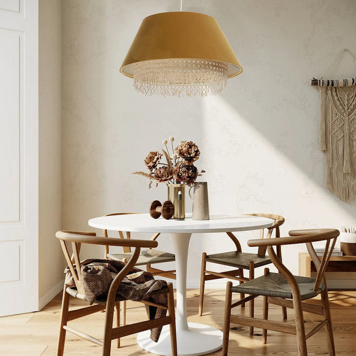 Suspension luminaire sensei rattan moutarde avec bord texturé à franges suspendue au-dessus d’une table à manger
