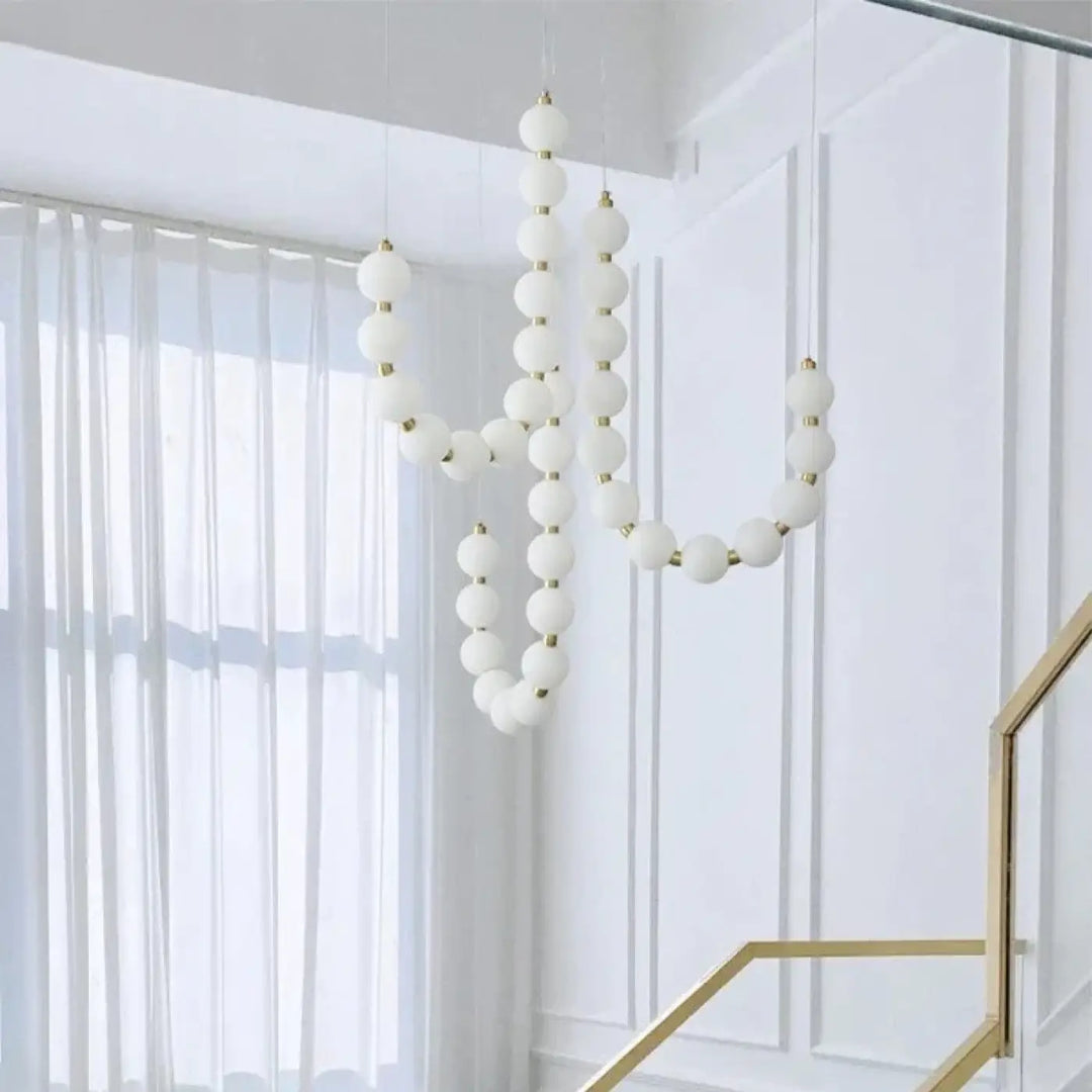 Suspension luminaire perlita sphérique blanche avec accents dorés pour créer une ambiance douce perles blanches