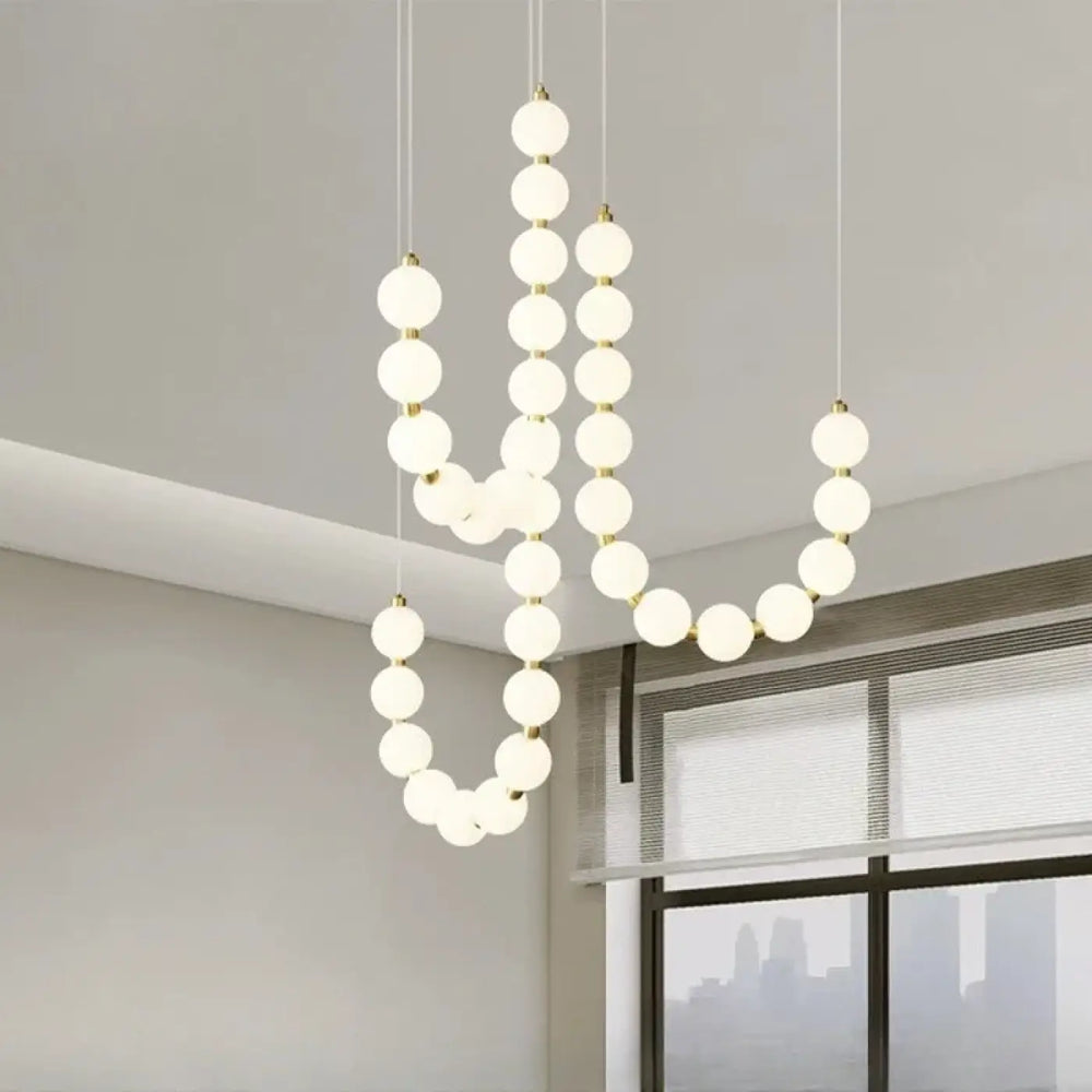Suspension luminaire perrita avec perles blanches en verre dépoli et structure métal doré pour une ambiance douce