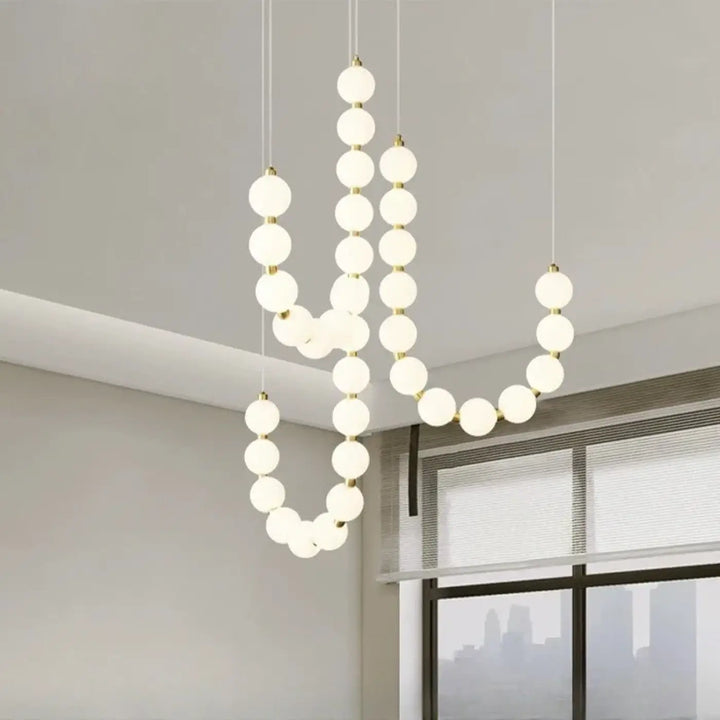 Suspension luminaire perrita avec perles blanches en verre dépoli et structure métal doré pour une ambiance douce