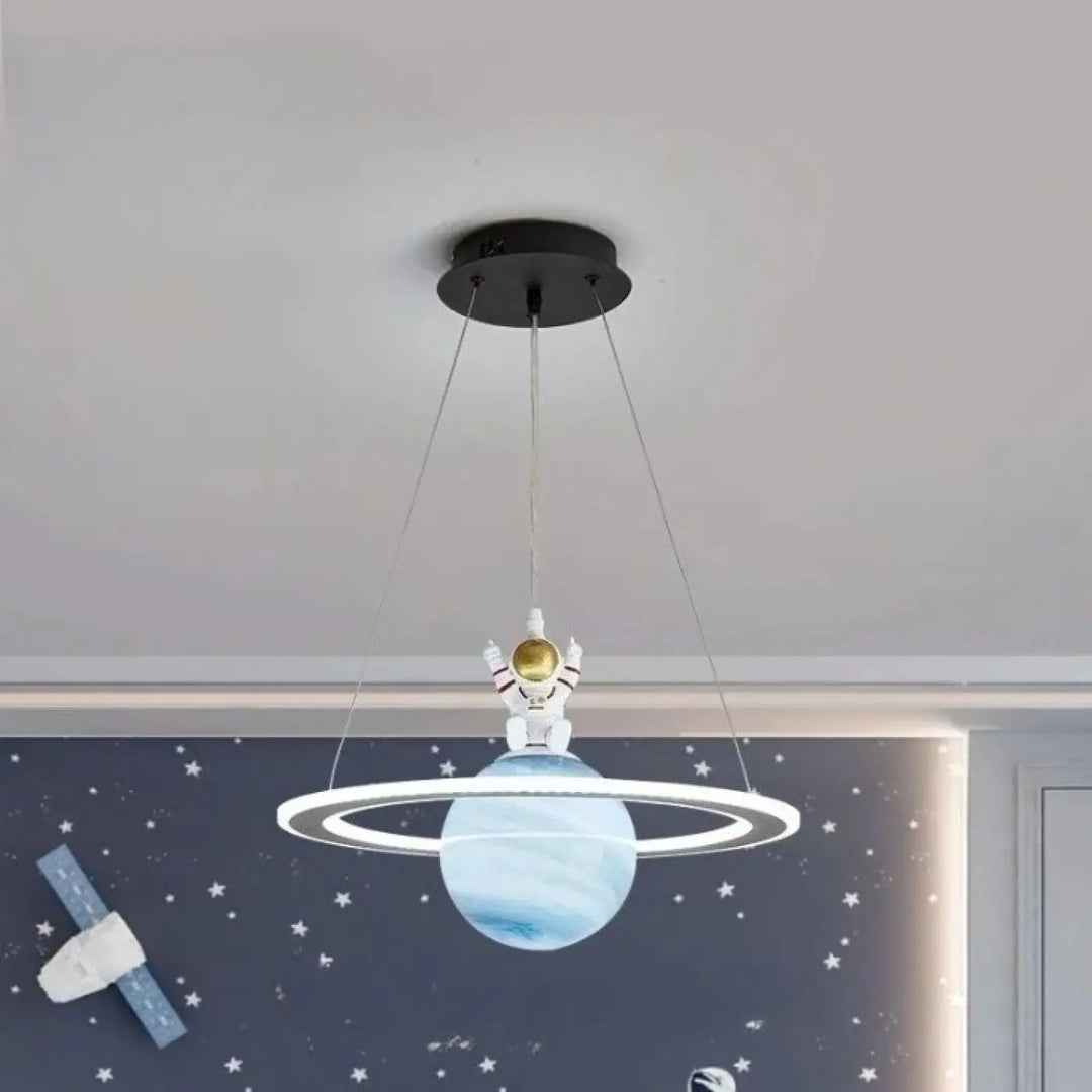 Suspension luminaire titania avec lumière blanche astronaute et planète bleue à anneaux suspendue au plafond noir