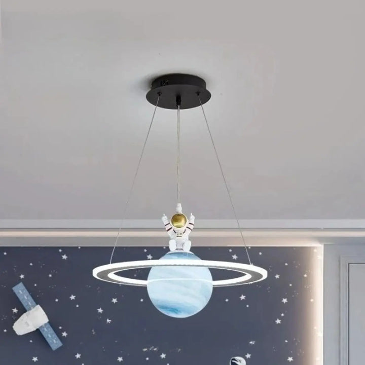 Suspension luminaire titania avec lumière blanche astronaute et planète bleue à anneaux suspendue au plafond noir