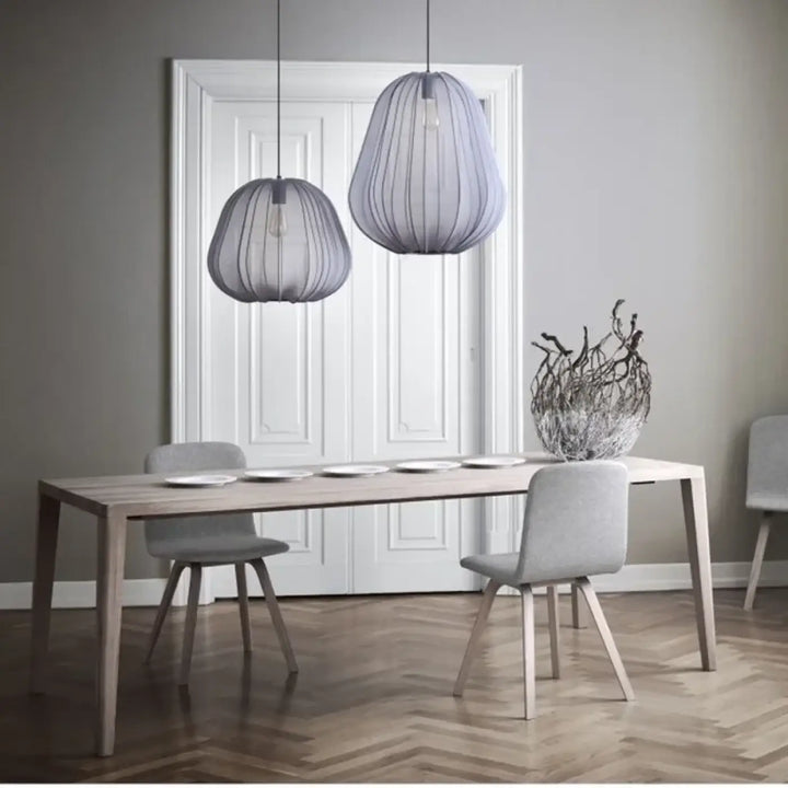 Suspension luminaire orbys en fil métallique gris avec design organique moderne au-dessus de la table à manger