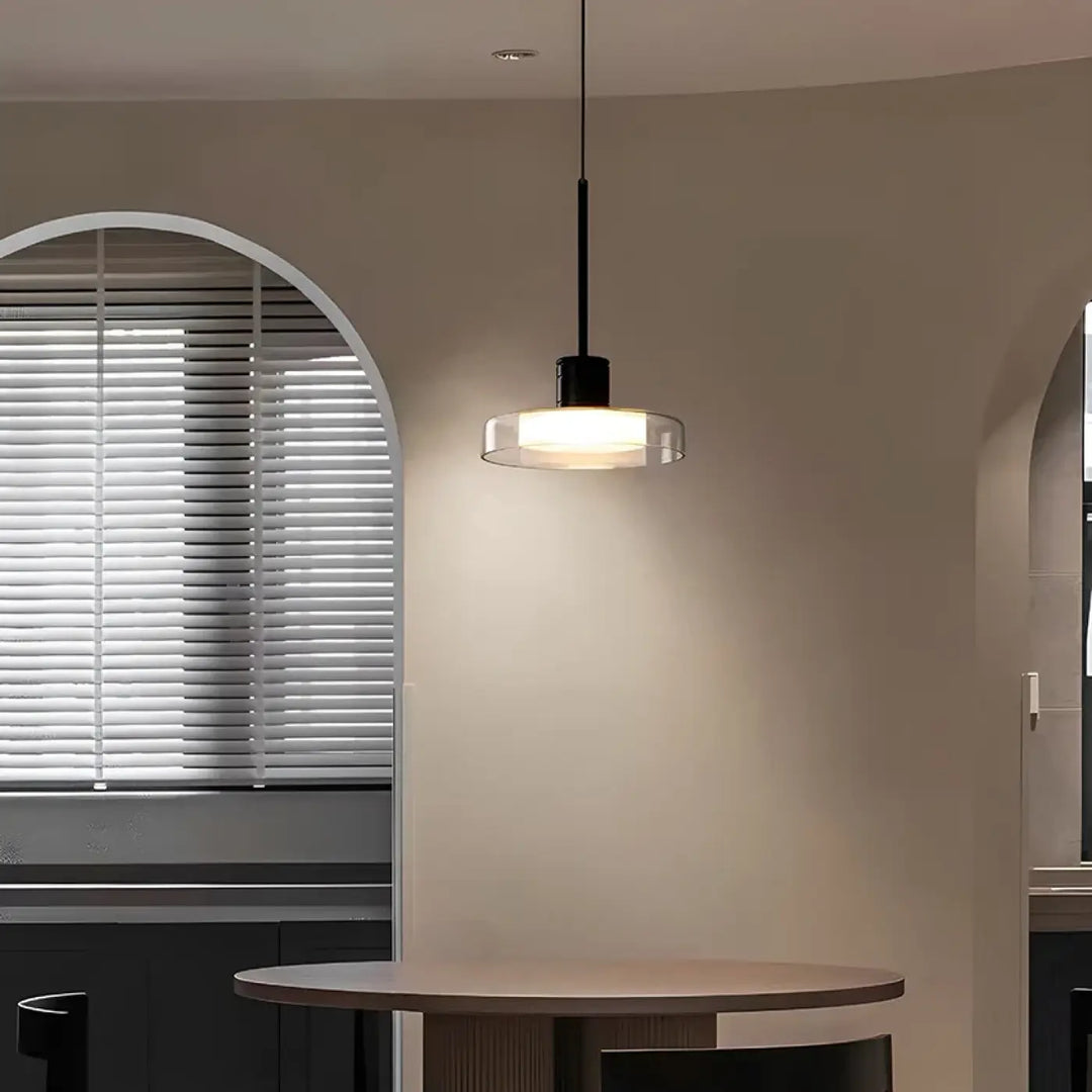 Suspension luminaire ronde avec tige noire et verre teinté transparent diffusant une lumière chaude et moderne