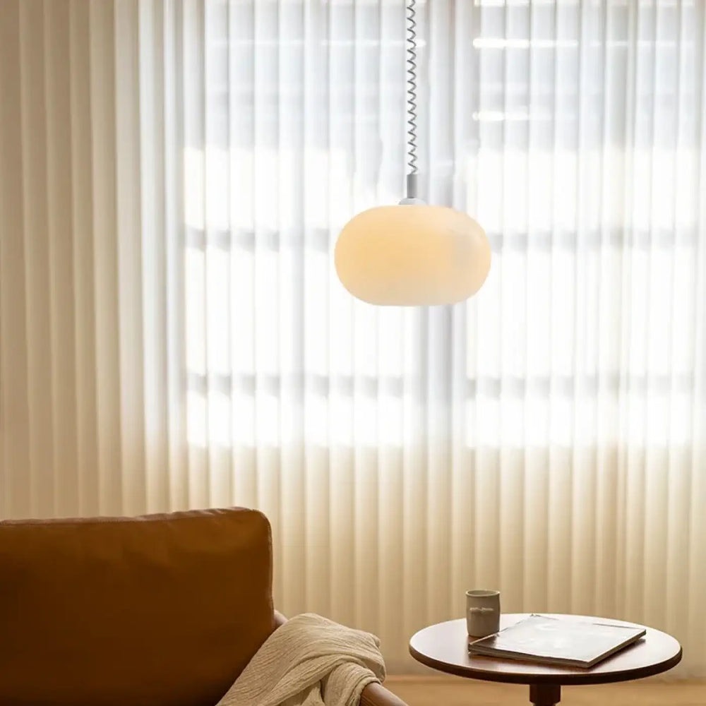 Suspension luminaire pendira en verre blanc avec forme ovale et câble spiralé en métal pour un éclairage doux