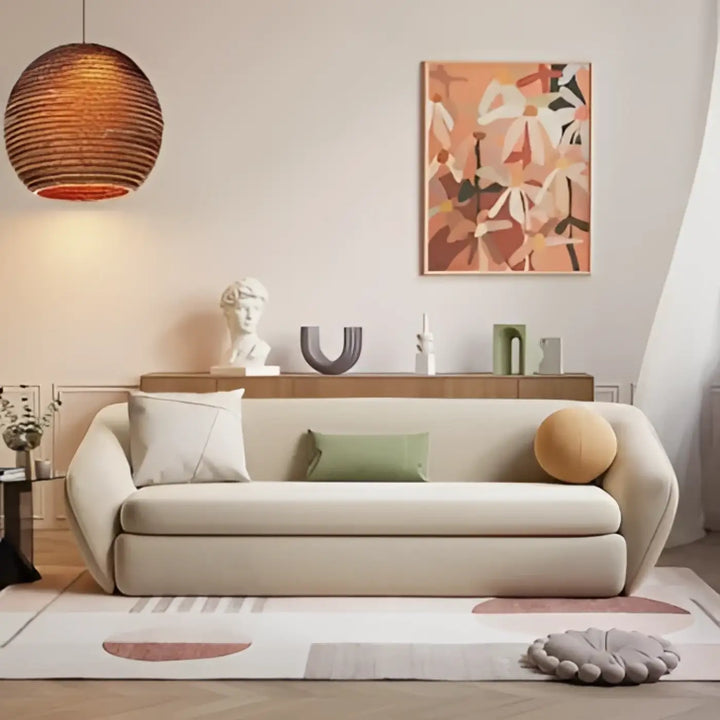 Canapé tapissé crème aux bras arrondis avec luminaire naturelle suspension luminaire nativa minimaliste