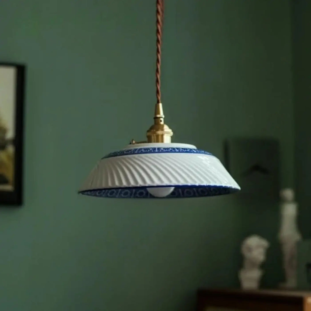 Photos montrent une suspension luminaire nara en céramique blanc et bleu nervurée avec une fixation en laiton