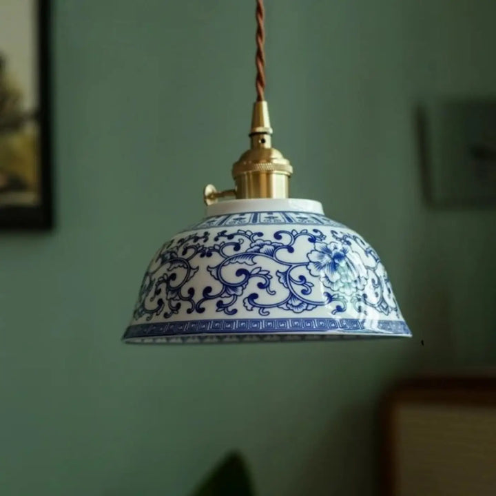 Photos montrent une suspension luminaire nara en porcelaine bleue et blanche avec motifs floraux complexes