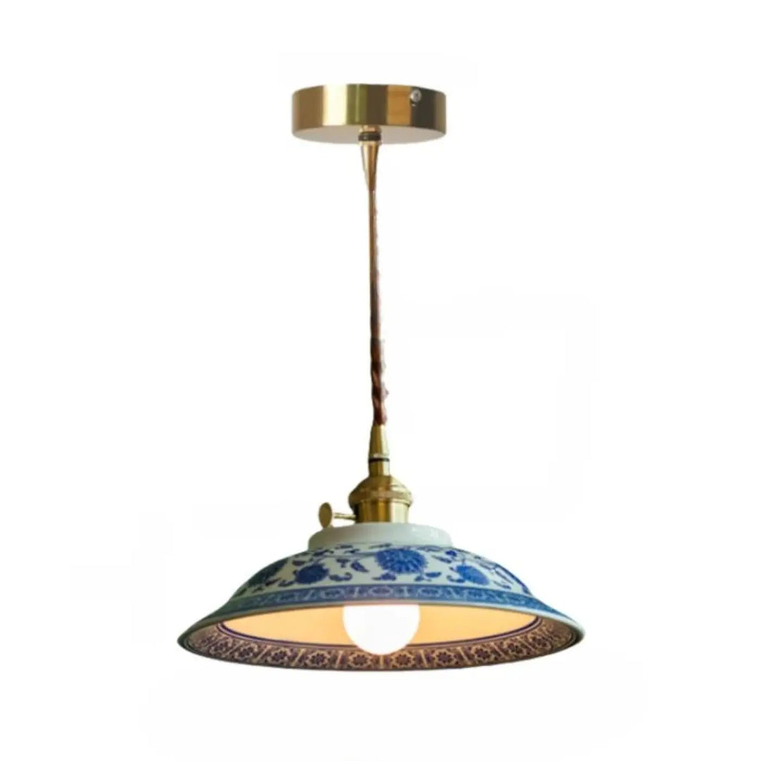Photos montrent une suspension luminaire nara en porcelaine bleu et blanc avec support plafond finition laiton et cordon torsadé