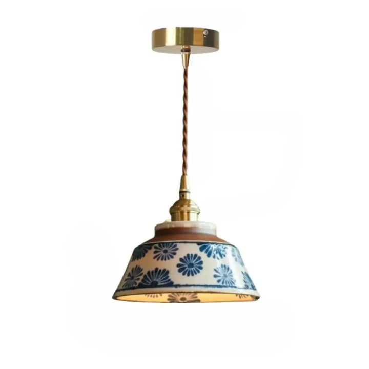Photos montrent une suspension luminaire nara en céramique bleue et blanche à motifs floraux suspendue par un cordon en laiton torsadé