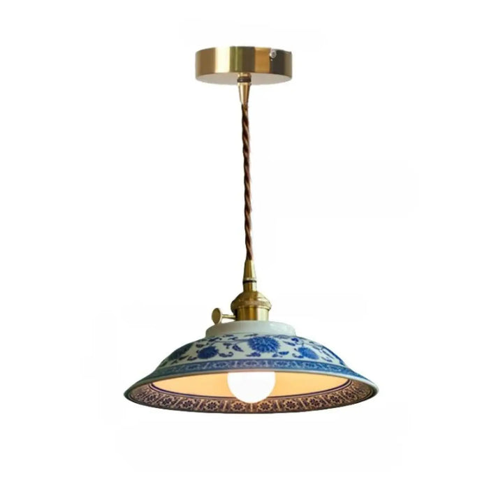 Photos montrent une suspension luminaire nara en porcelaine bleue et blanche avec fixation plafond laiton et cordon torsadé