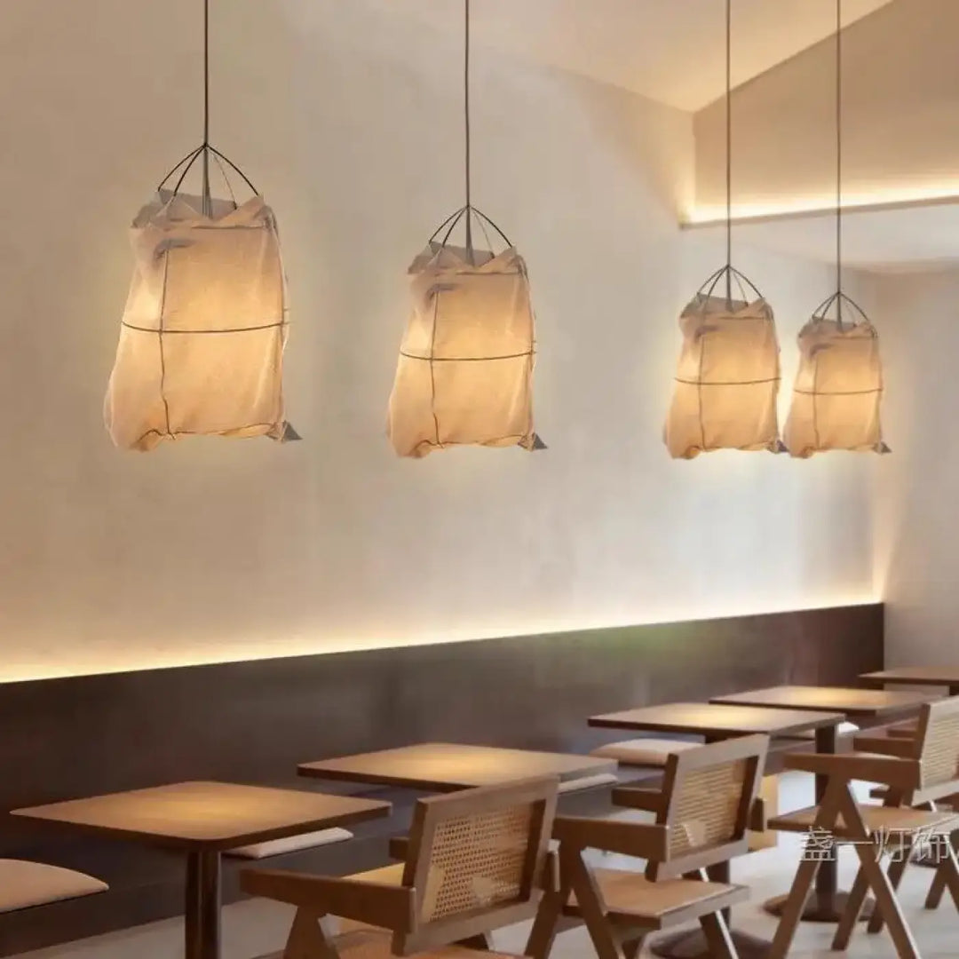 Suspension luminaire lima avec quatre lanternes en tissu beige diffuses et cadre métal noir style scandinave