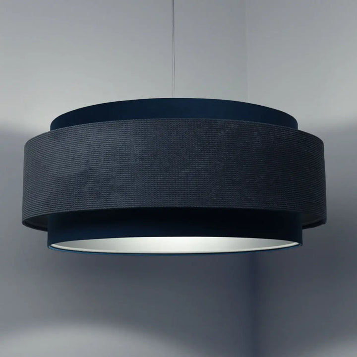 Suspension luminaire doblo classic en tissu bleu clair avec corps cylindrique texturé gris foncé et intérieur argent réfléchissant