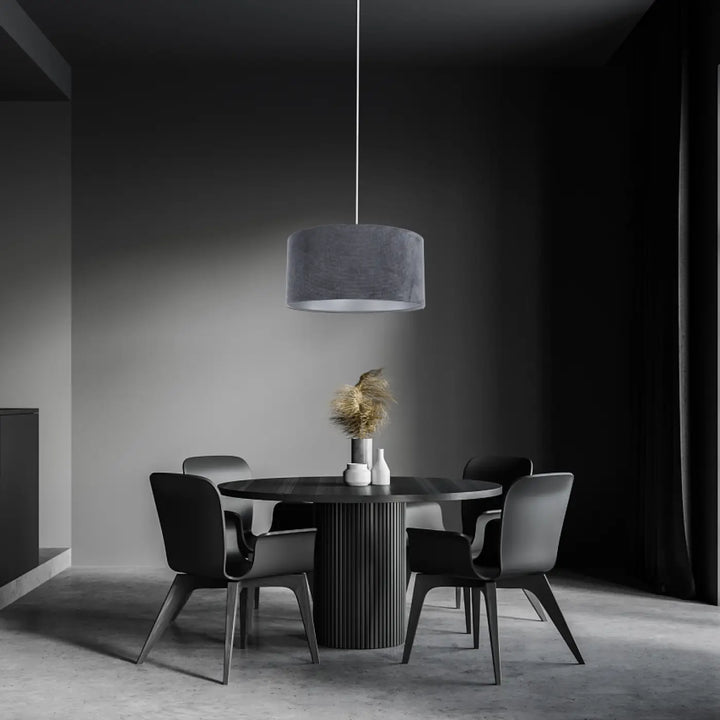Suspension luminaire cylindrique avec abat-jour en velours tissu graphite suspendue au-dessus d’une table