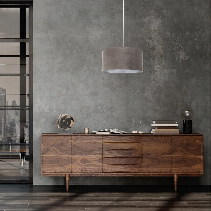 Une suspension luminaire glamour structural velour marron argent avec un buffet en bois foncé au design mid-century modern
