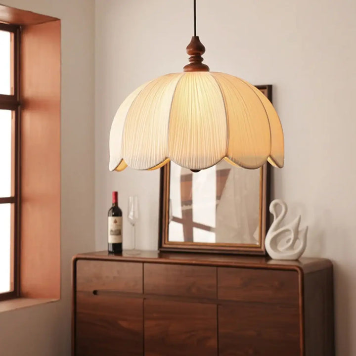 Suspension luminaire arssu avec abat-jour en tissu plissé crème et dessus en bois forme pétale, finition tissu plissé