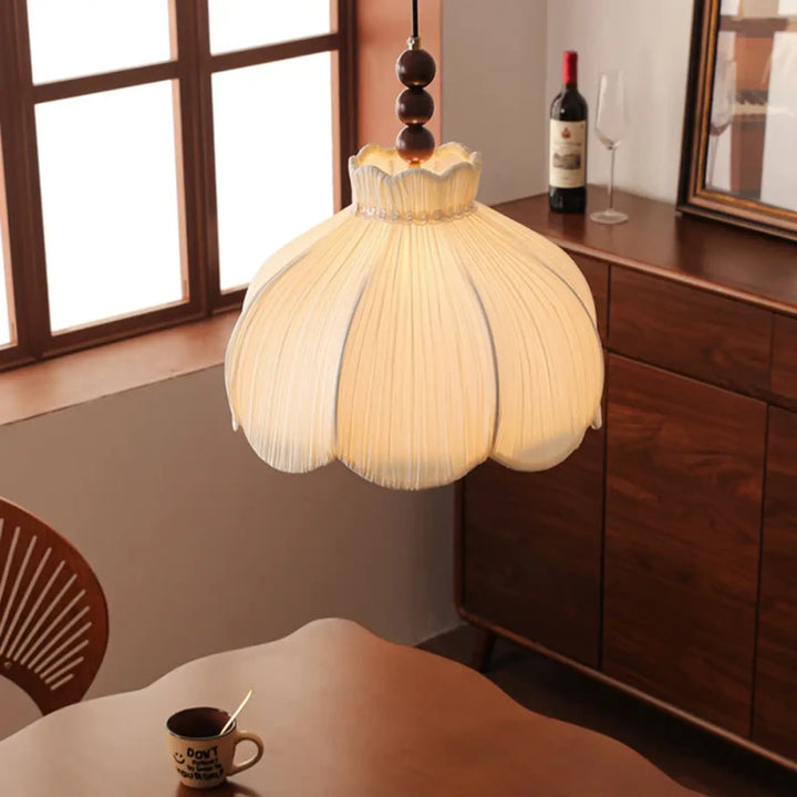 Suspension luminaire cream color with fini tissu plissé and wooden bead chain hanging from ceiling