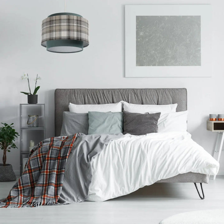 Lit gris avec tête de lit capitonnée et literie blanche, coussins gris et tissu turquoise pour suspension luminaire doblo
