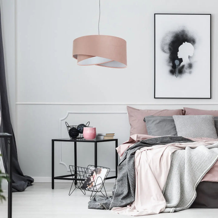 Une suspension luminaire cylindrique en tissu vieux rose avec un abat-jour en couches gris clair suspendue au plafond