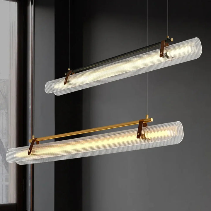 Deux suspensions luminaires rizor en verre cannelé avec finition dorée et accents en laiton suspendues au plafond