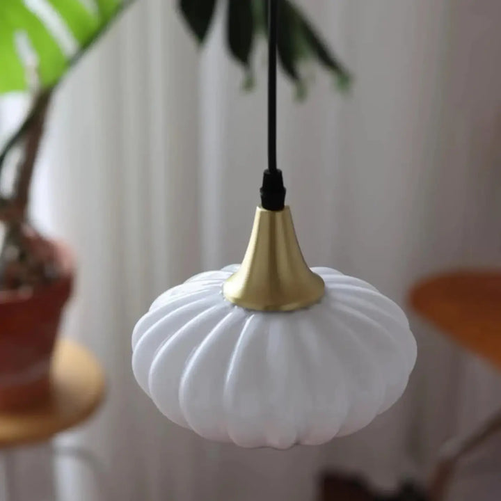 Suspension luminaire scandi en verre opalin blanc nervuré avec fixation métal doré et lumière douce suspendue par câble noir