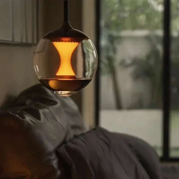 Suspension luminaire lumina en verre sphérique moderne avec un diffuseur central lumineux texturé et une lueur ambre chaleureuse