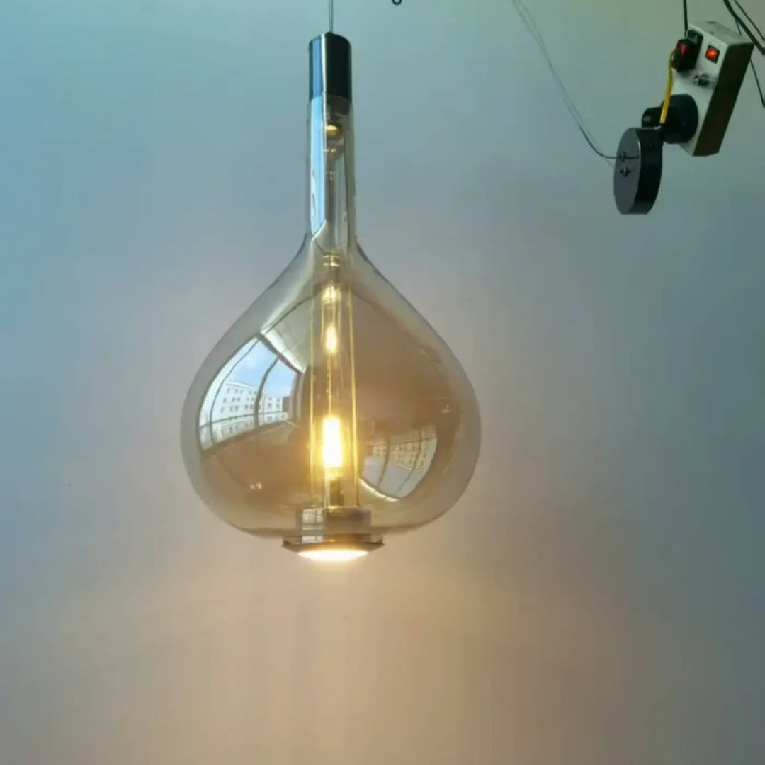 Suspension luminaire elys avec verre soufflé clair et accents métalliques effet fumé et filament lumineux visible