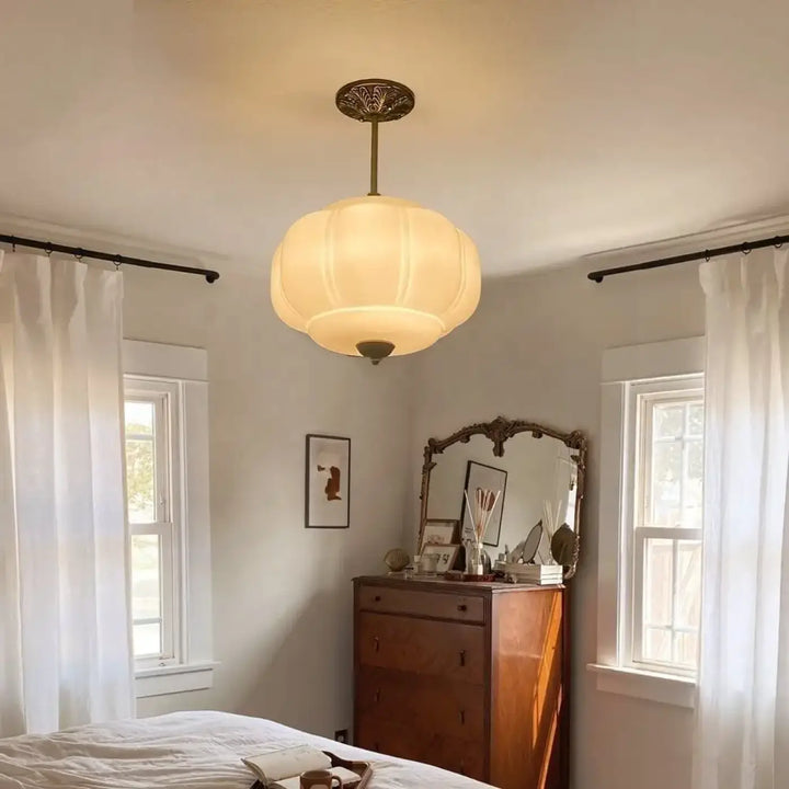 Suspension luminaire cream color softly glowing with vintage brass fixture and segmented glass shade for décoration intérieure art déco
