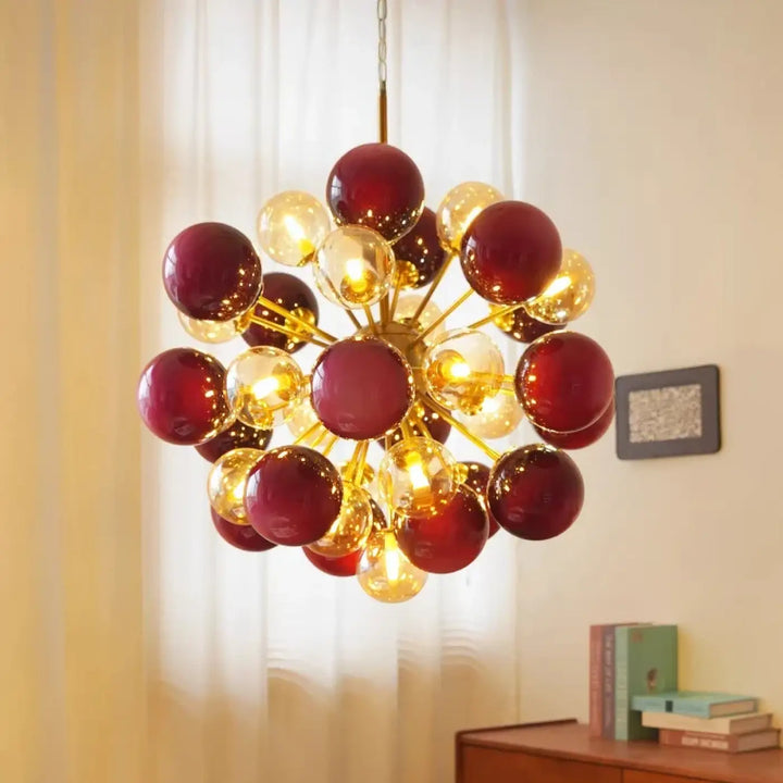 Suspension luminaire vintage samibia avec structure métallique dorée et orbes en verre rouge profond et ambre