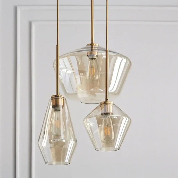 Set de trois suspensions luminaires avec verre transparent et métal doré finition brass pour intérieur moderne
