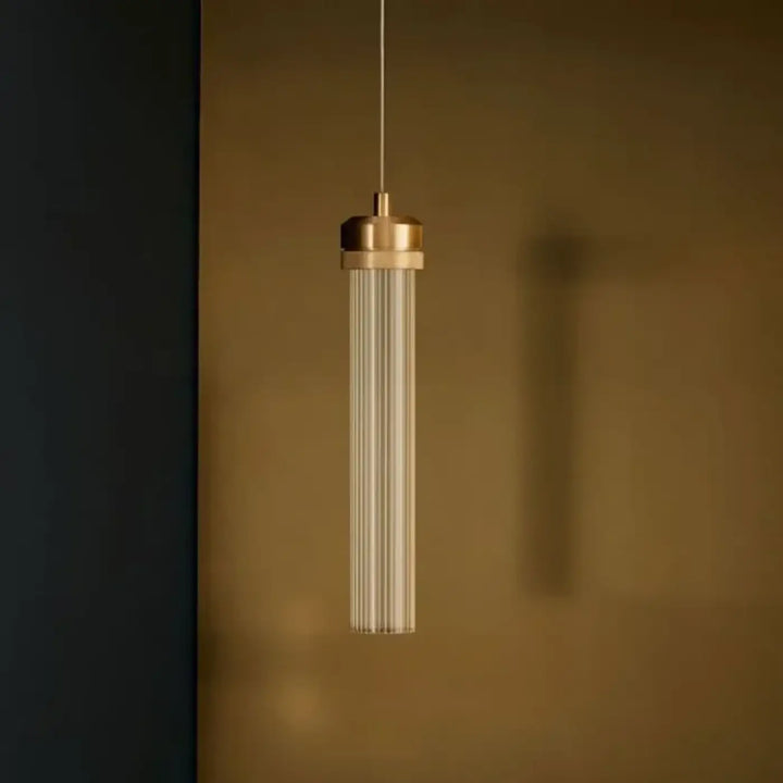 Suspension luminaire ilia avec top en laiton et corps en verre rainuré pour suspension minimaliste au-dessus d’une table