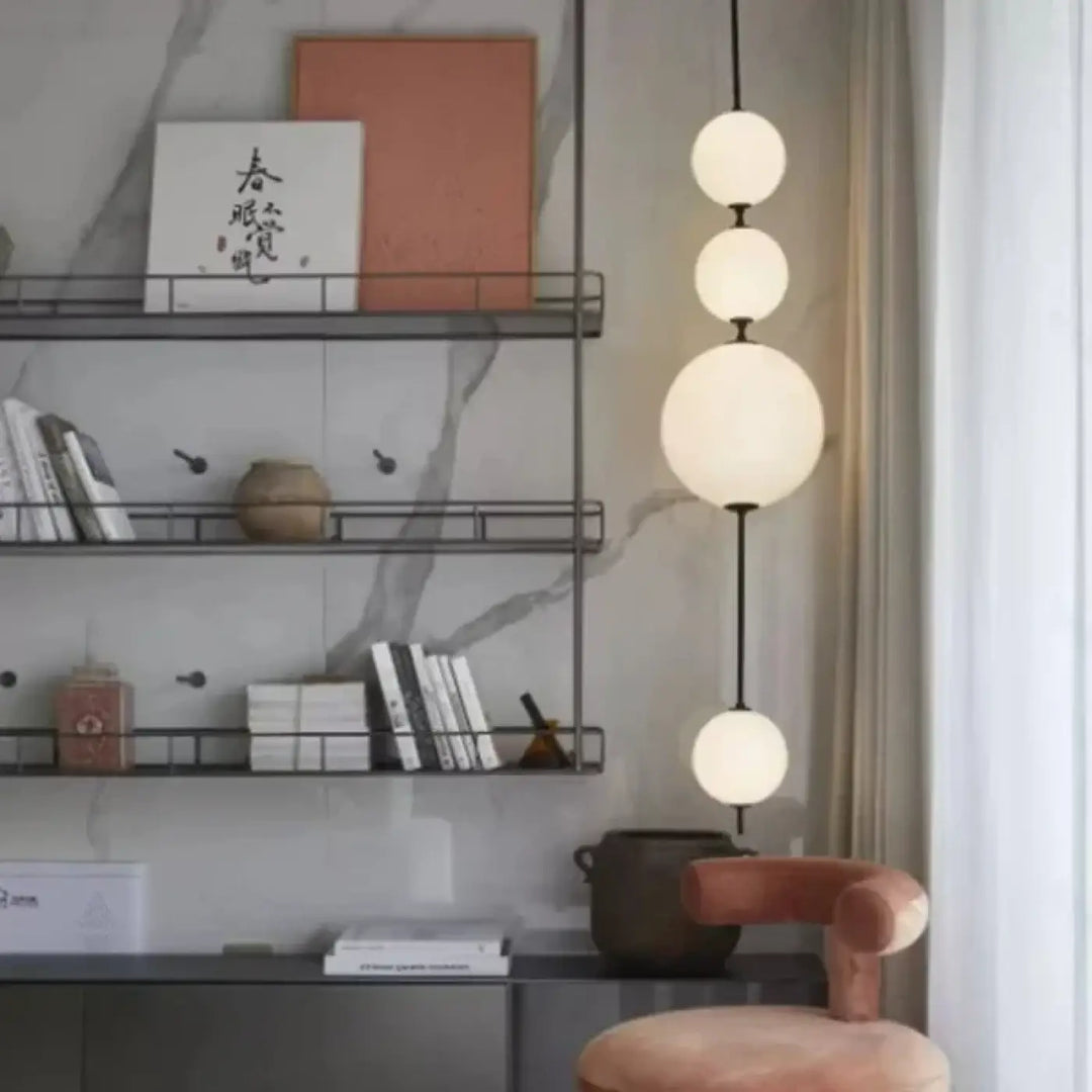 Suspension luminaire saku avec quatre sphères en verre dépoli suspendues sur une tige noire design scandinave moderne