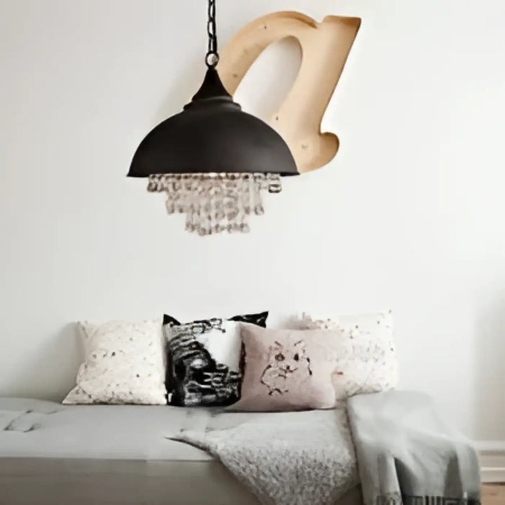 Suspension luminaire métal noir avec accents cristal suspendue au-dessus dun canapé gris pour décoration intérieure
