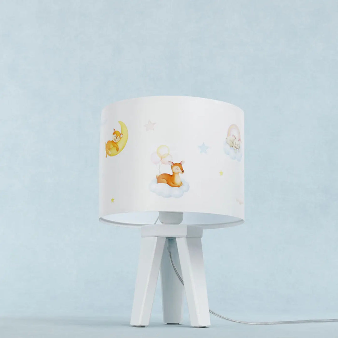 Lampe de table sweet dreams blanche avec abat-jour cylindrique orné de cerfs et lune sur base trépied minimaliste