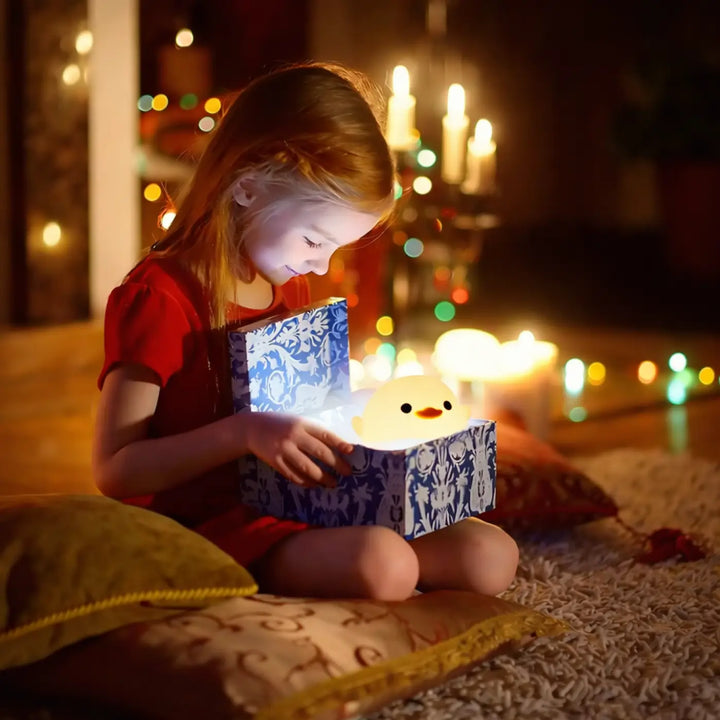 Veilleuse caneton jaune doux et lumineux en forme de canard en caoutchouc dans une boîte cadeau décorative pleine bleue et blanche