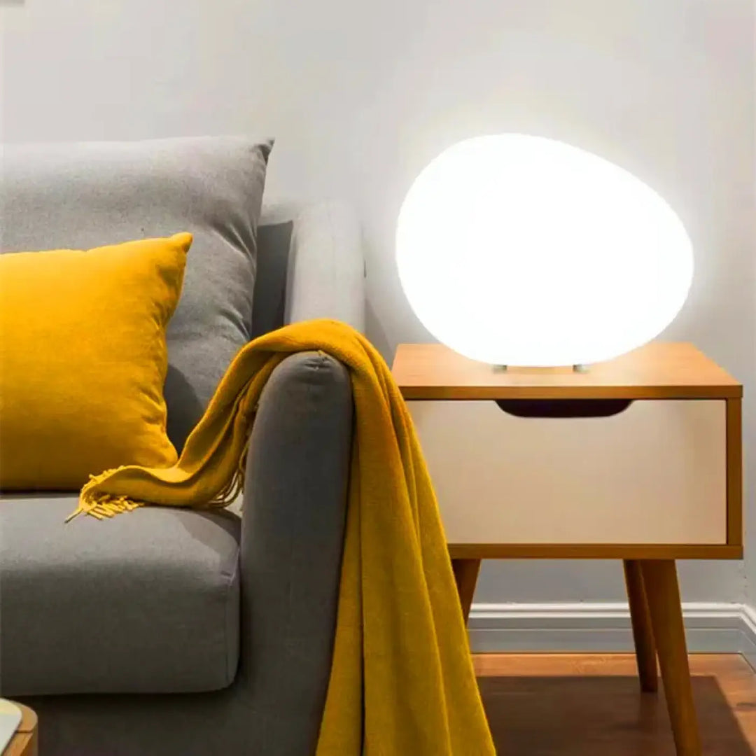 Veilleuse contemporaine inspirée d’un galet en led blanche ovale minimaliste sur une table en bois eluna