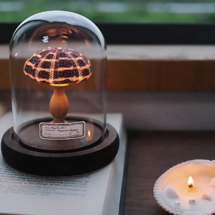 Veilleuse marina lampe champignon en crochet avec chapeau marron foncé et crème sous cloche en verre sur socle noir