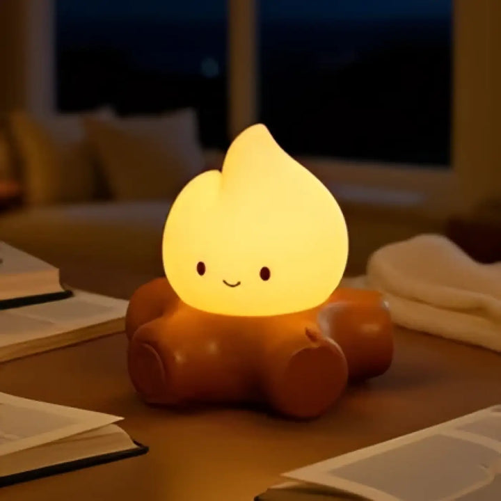 Veilleuse camp cosy en forme de flamme jaune avec visage souriant et base marron pour une ambiance chaleureuse d’un feu