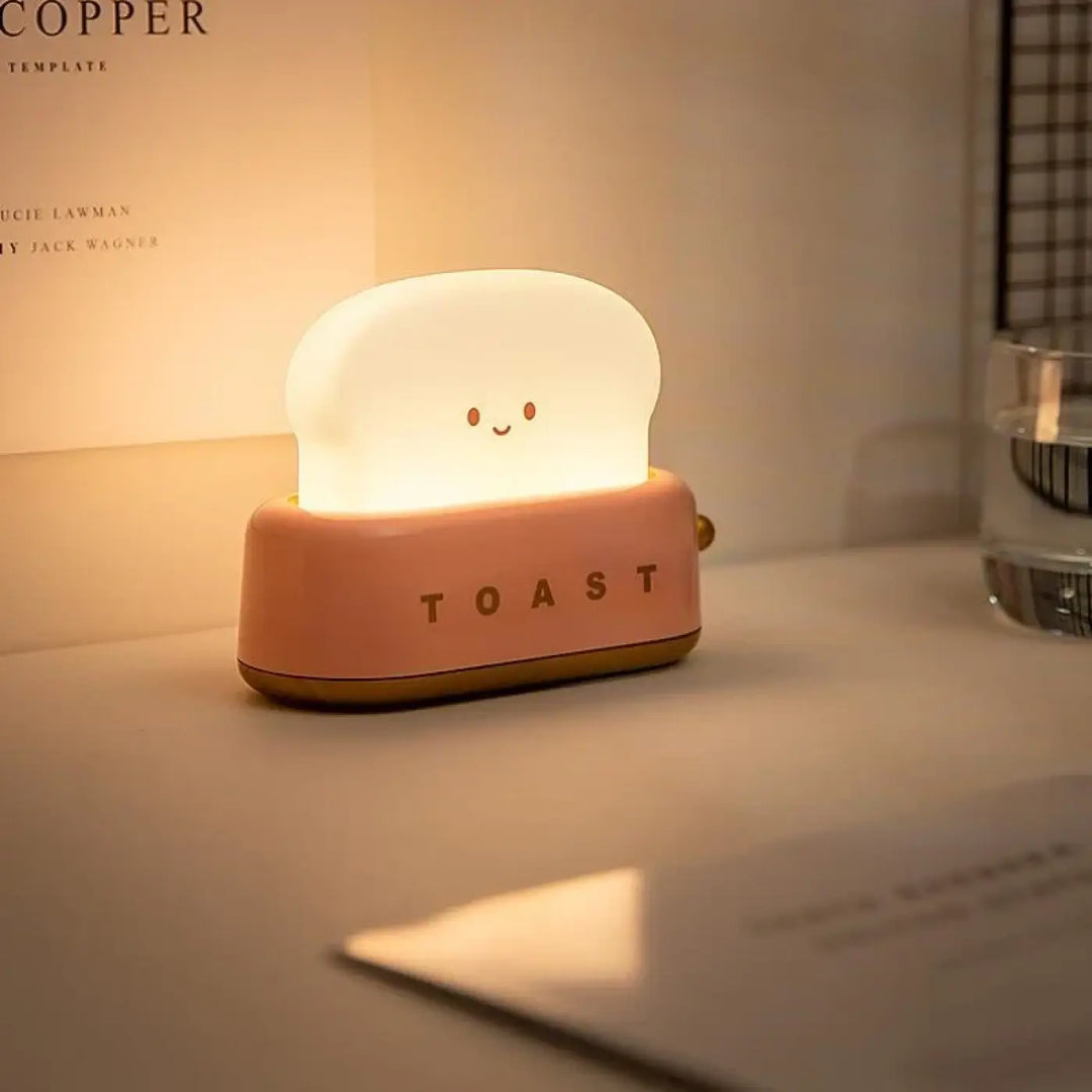 Veilleuse kawaii toast en silicone rose doux en forme de tranche de pain souriante avec lumière douce intégrée