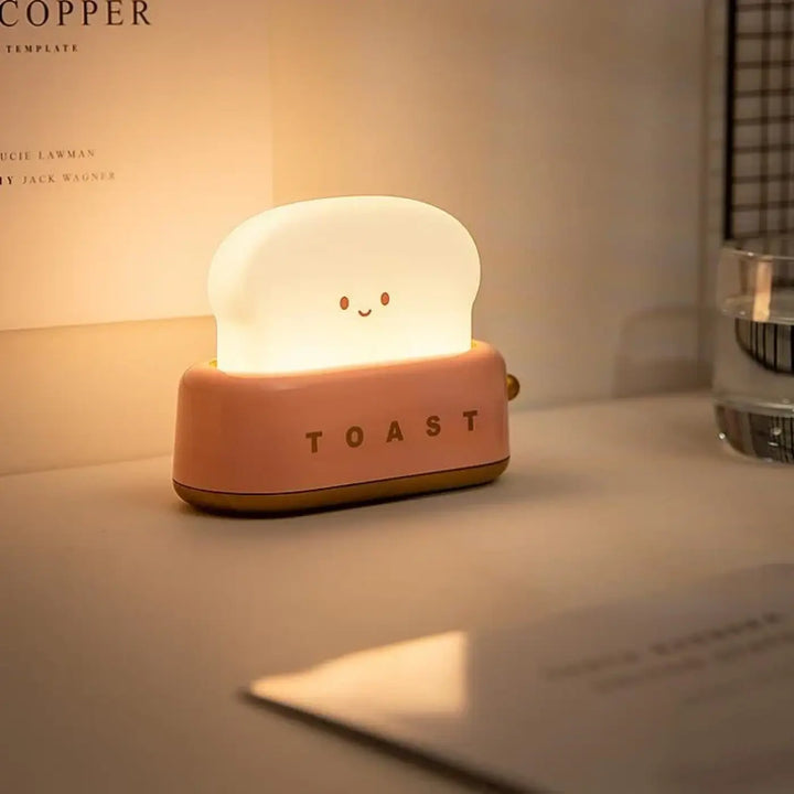 Veilleuse kawaii toast en silicone rose doux en forme de tranche de pain souriante avec lumière douce intégrée