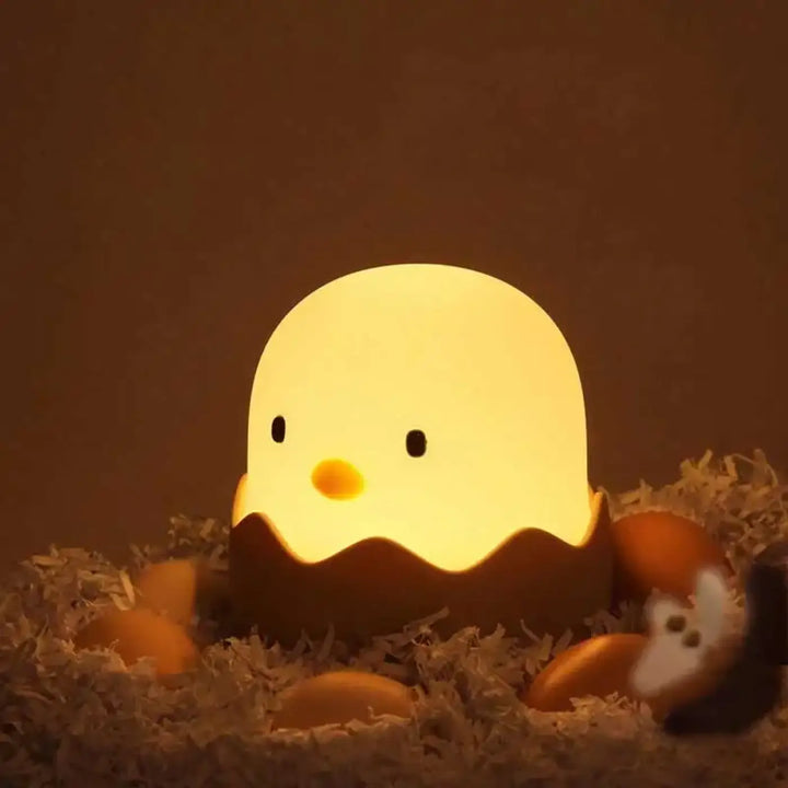 Veilleuse led douce ptibou en forme de poussin jaune lumineux dans une coquille dœuf marron