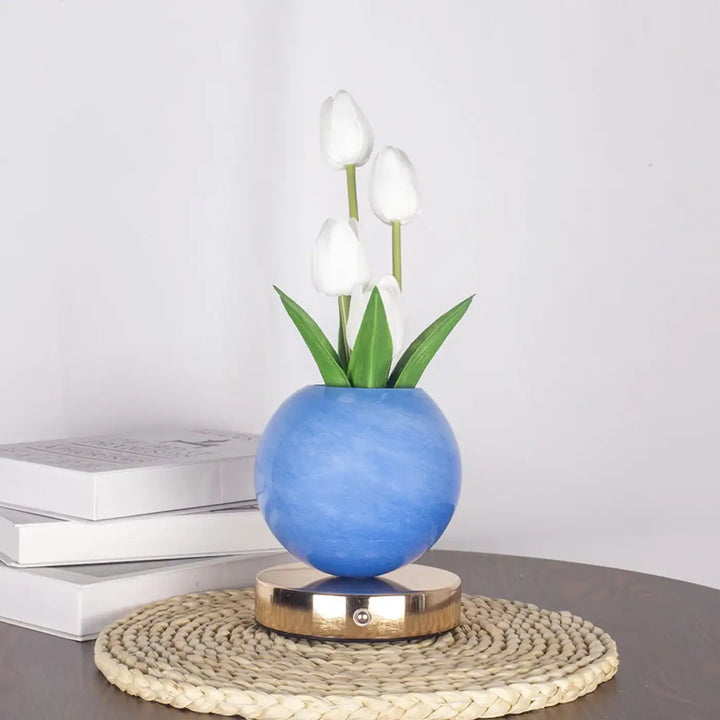 Lampe de table tulyna avec vase en céramique bleu sphérique, tulipes blanches, feuilles vertes, base magnétique dorée comme source lumineuse