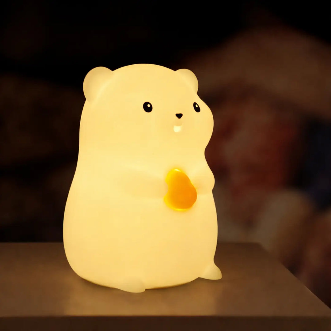 Veilleuse magique animalix en peluche jaune doux en forme de hamster avec une touche lumineuse en cœur orange lumineux joue