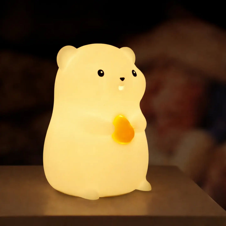 Veilleuse magique animalix en peluche jaune doux en forme de hamster avec une touche lumineuse en cœur orange lumineux joue