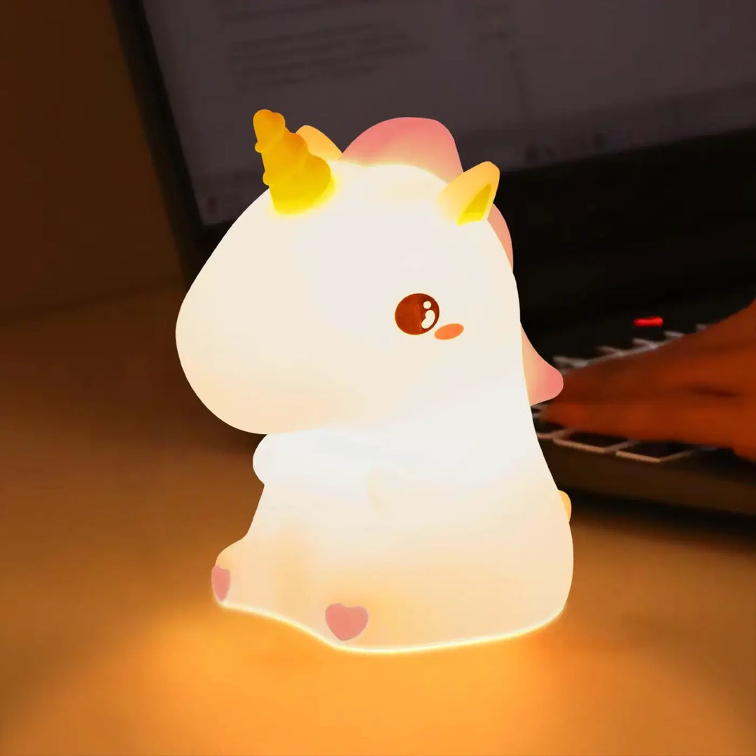 Veilleuse magique animalix en forme de licorne blanche avec corne jaune et touche lumineuse rose douce sur bureau